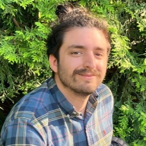 Profile image of Kerry in front of bushes.